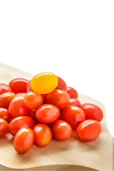 Haufen Kirschtomaten auf einem Holzschneidebrett — Stockfoto