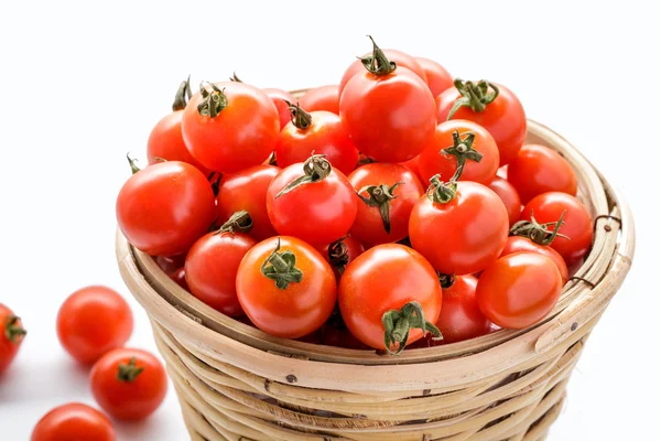 Haufen Kirschtomaten in einem Rattankorb — Stockfoto