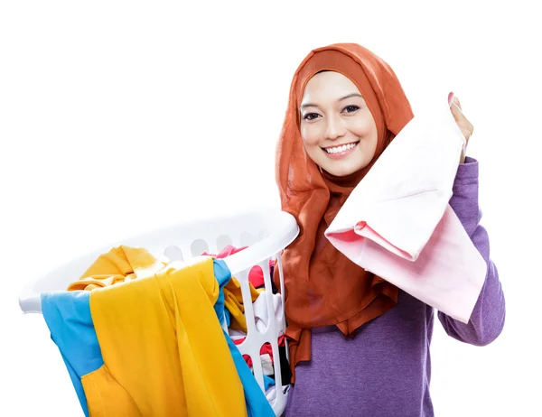Ama de casa con hijab llevando cesta de la ropa y recoger uno —  Fotos de Stock