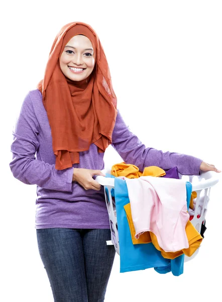 Hermosa mujer sonriente usando hijab sosteniendo una cesta de lavandería —  Fotos de Stock