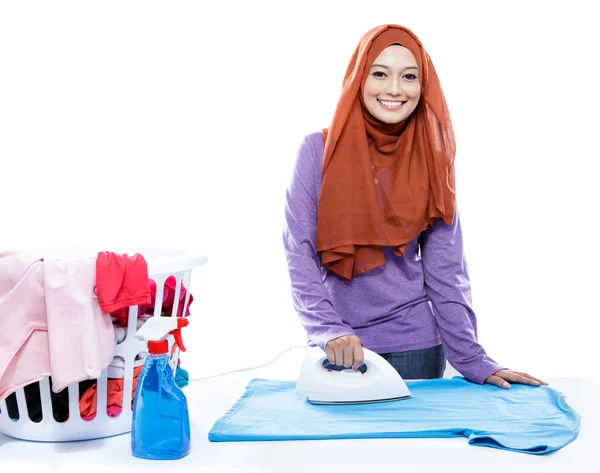 Young woman wearing hijab ironing clothes — Stock Photo, Image