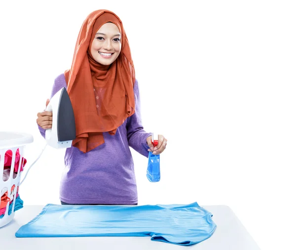 Mujer joven que usa hijab jolding hierro y perfume spray — Foto de Stock