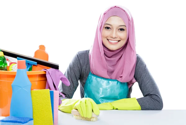 Jovem dona de casa vestindo hijab limpeza de uma mesa usando escova — Fotografia de Stock