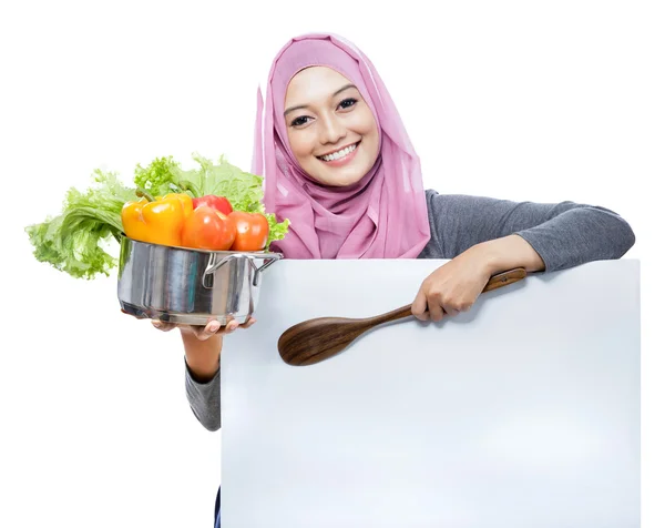 Jonge lachende vrouw met een pan met groenten en houten — Stockfoto