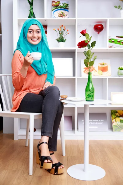 Ελκυστική μουσουλμανική γυναίκα που κάθεται και τραπεζίου ένα φλιτζάνι τσάι — Φωτογραφία Αρχείου