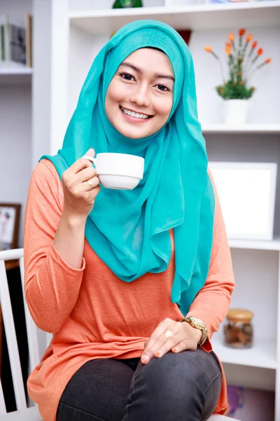 Όμορφη μουσουλμανική γυναίκα, χαμογελαστά, κρατώντας ένα φλιτζάνι τσάι — Φωτογραφία Αρχείου