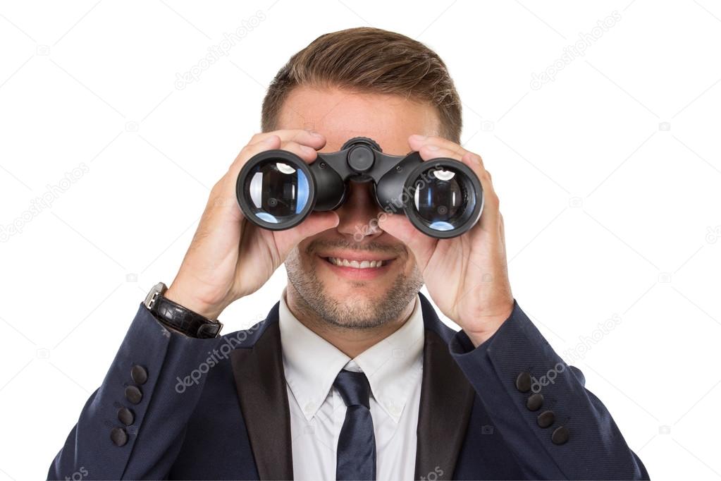 Businessman smiling while using a binocular