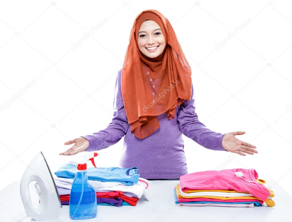 young woman wearing hijab presenting clean and tidy clothes afte