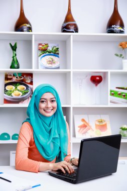 beautiful young muslim woman working on her laptop