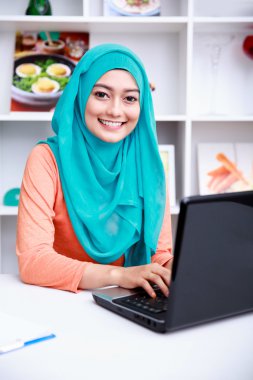 beautiful young muslim woman working on her laptop