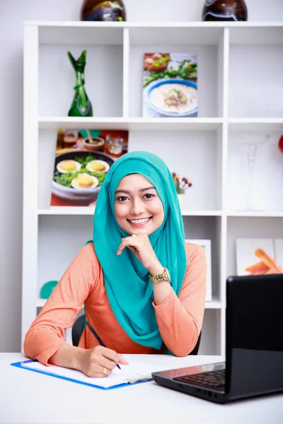 Junge Frau schreibt im Büro eine Information aus dem Internet — Stockfoto