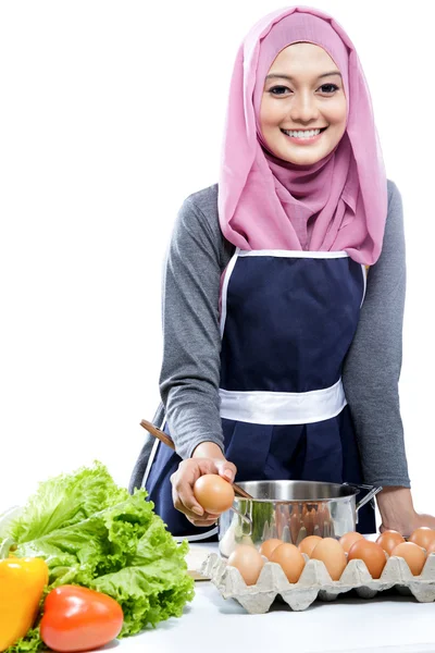 Mujer joven preparando una comida con ingredientes en la tabla — Foto de Stock