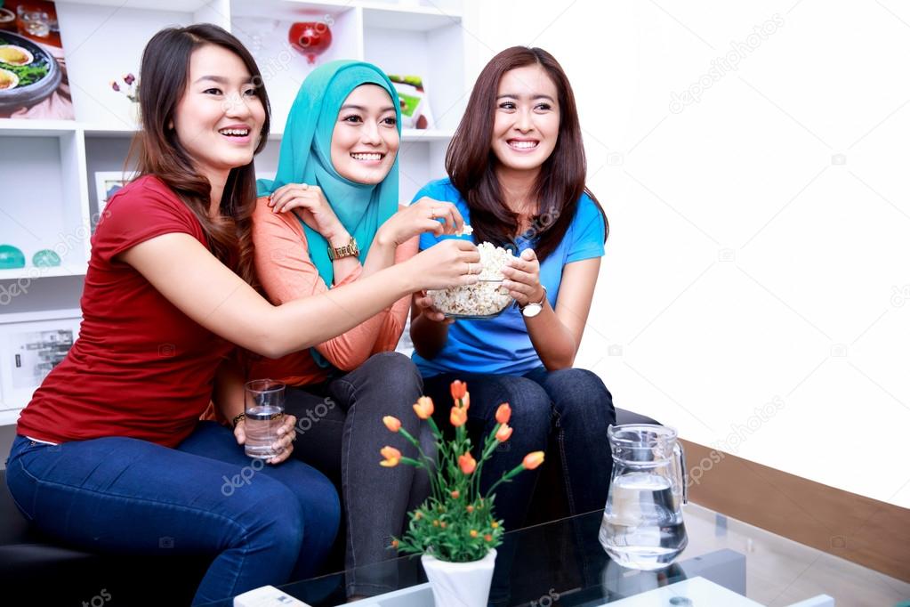 women friends snacking popcorn