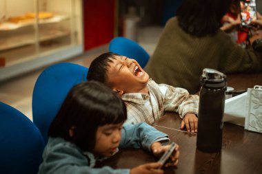 Çocuklar birlikte oynarken neşeyle kahkahaları ve keyifli anları paylaşıyorlar.