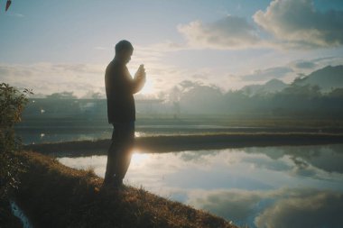 Yansıtıcı su arka planına karşı bir figürle çekilen sakin bir an..