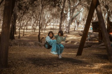 İki yakın arkadaş, huzurlu ve huzurlu bir ortamda sallanırken keyifli anlar paylaşırlar.