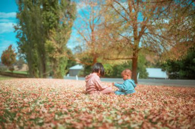 Çocuklar, huzurlu bir ortamda sonbaharın neşeli ve canlı renklerini yaşıyorlar.