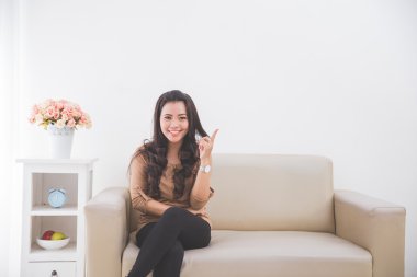 Boş beyaz duvara yukarıyı bir kanepede oturan kadın