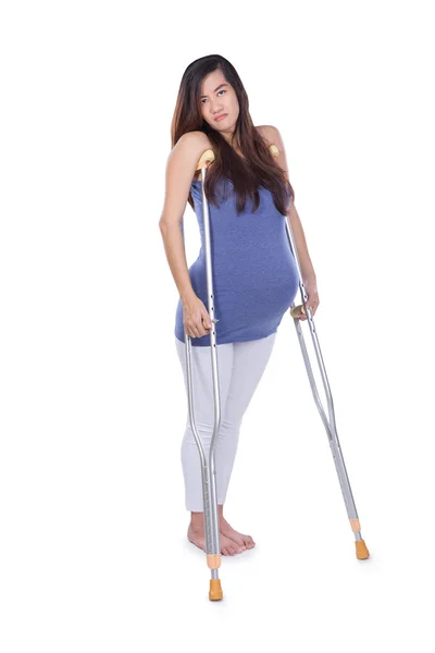 Potret panjang lengkap seorang wanita hamil menggunakan kruk, terisolasi — Stok Foto