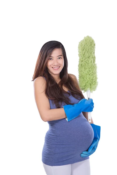 Asiático mulher grávida segurando um limpador enquanto sorrindo na parte traseira branca — Fotografia de Stock