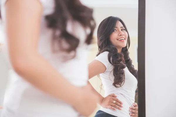 Vrouw op zoek naar haar imago op de spiegel — Stockfoto