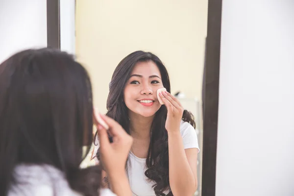 Женщина наносит макияж на лицо — стоковое фото