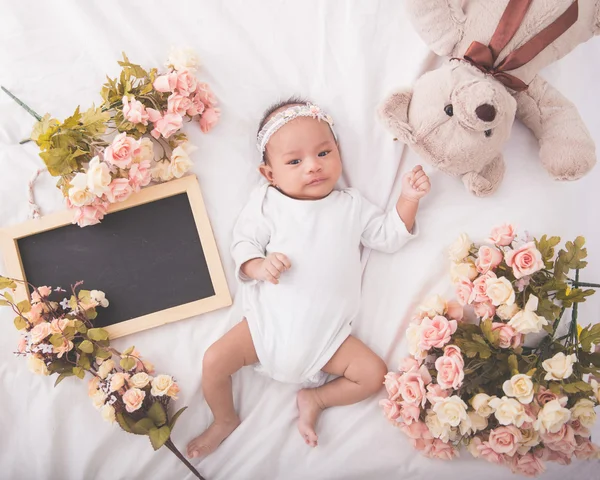 Cute asian baby girl on white blanket next to blank chalkboard, — Stock Photo, Image