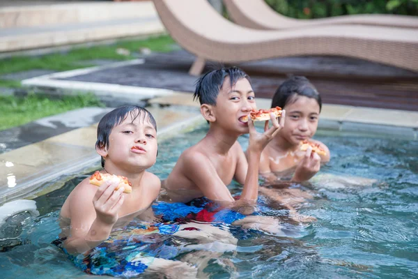 Tre pojkar njuter vid poolen — Stockfoto