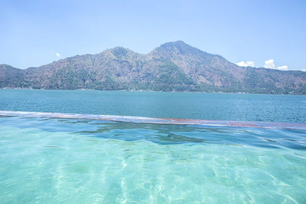 Infinity pool with lake and mountain at the background — Stock Photo, Image