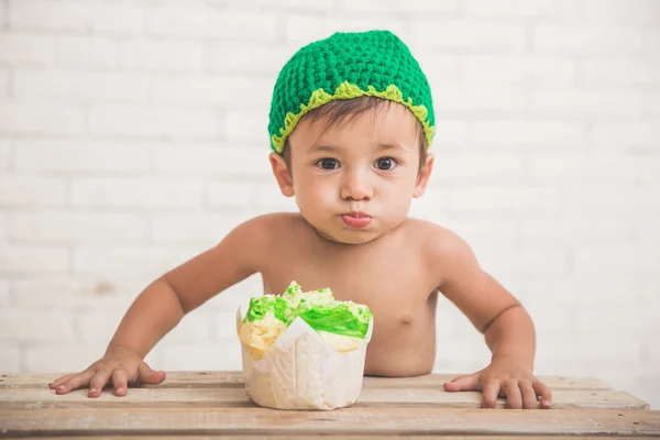 Lindo chico caucásico usando un sombrero de punto verde con un pan en fron —  Fotos de Stock