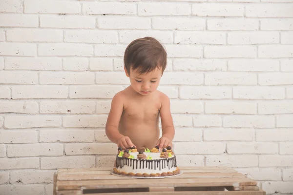 Bonito caucasiano menino jogar com seu aniversário bolo — Fotografia de Stock
