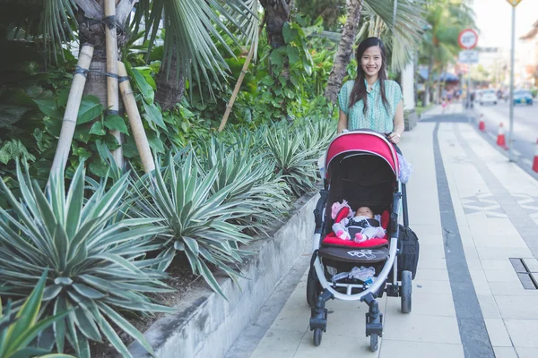 Vrouw een wandeling met haar baby binnen de baby wandelwagen — Stockfoto