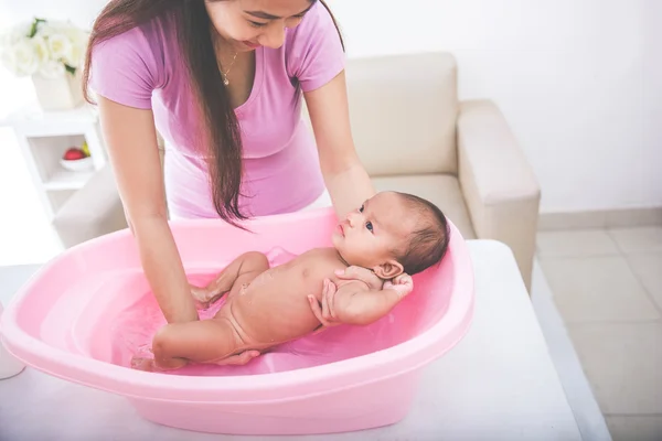 Meisje van de baby is wordt gebaad door zijn moeder — Stockfoto