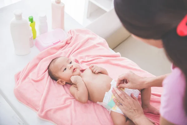 Mamma satte på en baby blöja till hennes nyfödda — Stockfoto