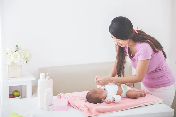 Maman a mis des vêtements pour son bébé — Photo