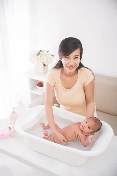 Bebê está sendo banhado por sua mãe — Fotografia de Stock
