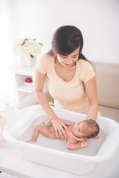 Baby wordt gebaad door zijn moeder — Stockfoto