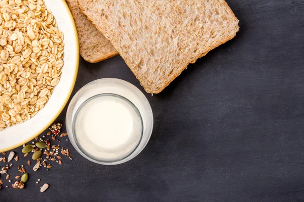 Une bouteille de lait, du pain sec et de la farine d'avoine pour le petit déjeuner — Photo