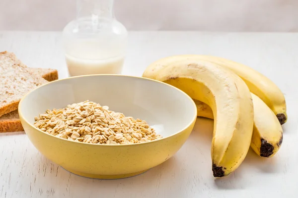 Σπιτικό και υγιεινό πρωινό, πλιγούρι βρώμης, γάλα, ψωμί στεγνό και μπανάνα — Φωτογραφία Αρχείου