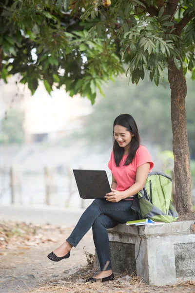 Młody student azjatyckich siedział zewnątrz, za pomocą laptopa — Zdjęcie stockowe