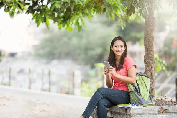 Fiatal ázsiai diák állandó szabadtéri, a mobiltelefon és a sm — Stock Fotó