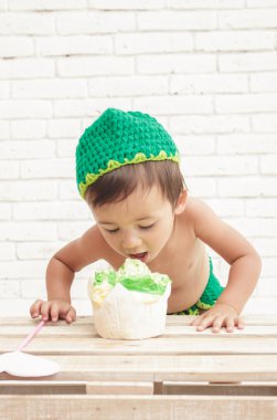 bir sünger kek yemek yeşil şapka yürümeye başlayan çocuk