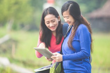 İki genç Asyalı öğrenciler Tablet PC'yi kullanma