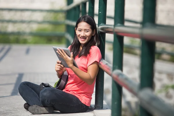 Jonge Aziatische student in haar outdoor activiteit, houden een tablet pc — Stockfoto