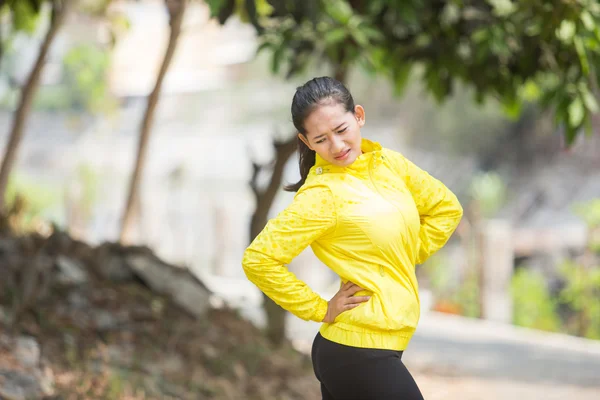 年轻的亚洲女人，行使室外穿着黄色霓虹灯夹克，参考 — 图库照片