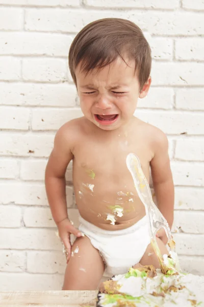 Handsome toddler crying while playing smash cake — Stock Photo, Image