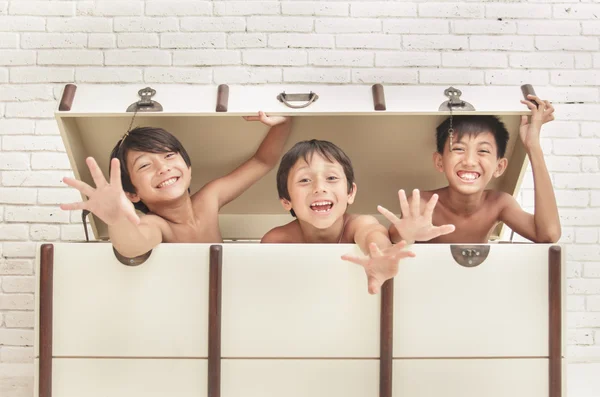 Expressão de três irmãos alegres dentro da caixa — Fotografia de Stock