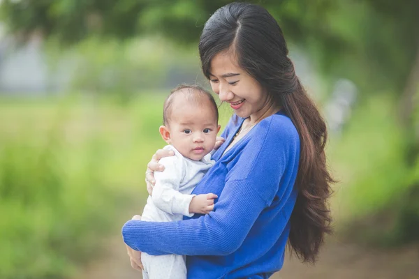 Mooie Aziatische moeder die haar baby dochter — Stockfoto