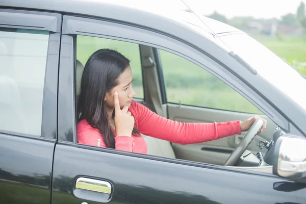 年轻的亚洲女人看起来她开车时的应力 — 图库照片