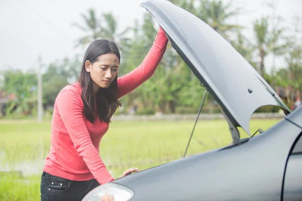Woman trying to fix her broken car — Stock Photo, Image